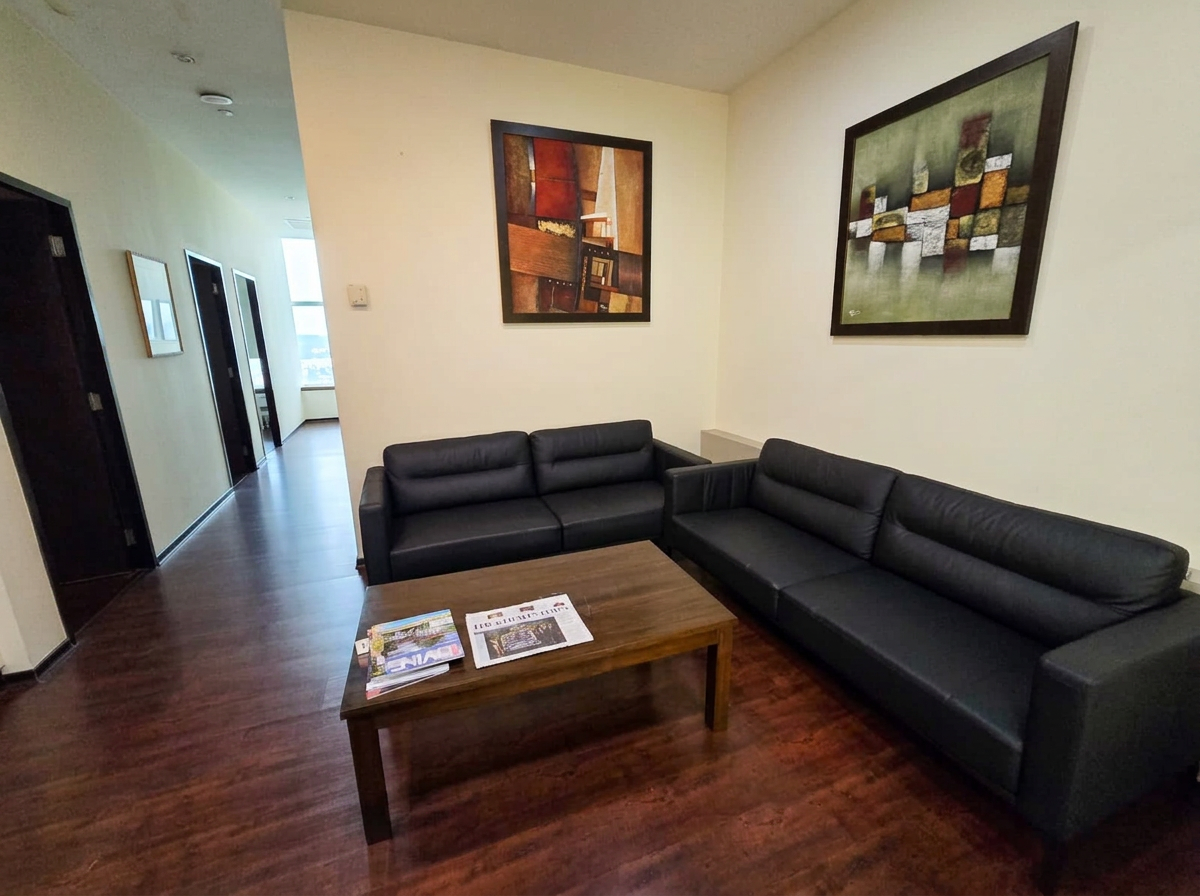 Second waiting area with sofas, coffee table and artwork